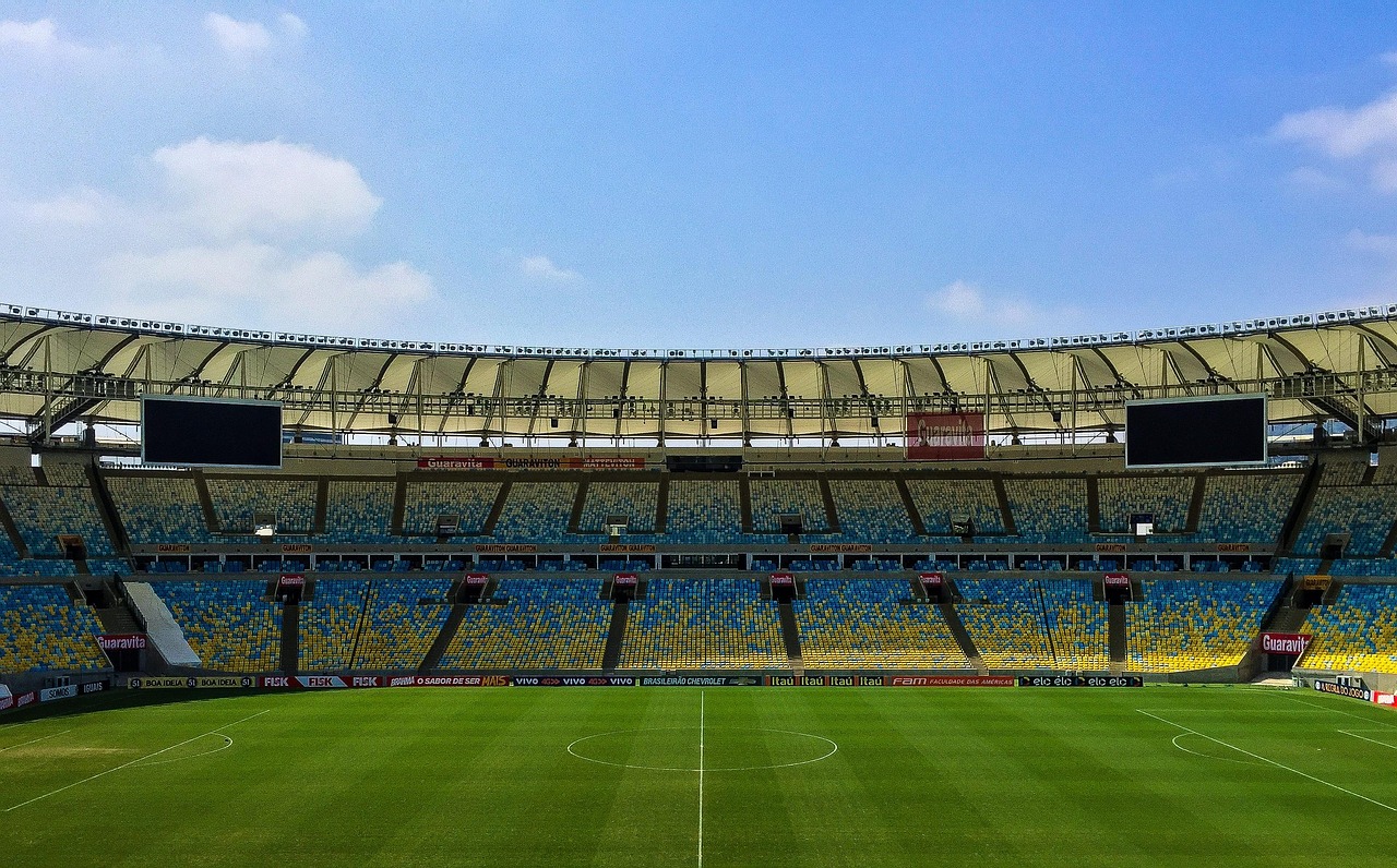 초록 잔디 위에서 축구공을 차는 선수의 역동적인 모습