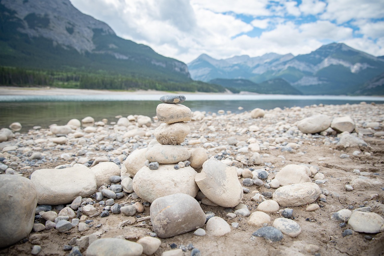 자연 속에 세워진 돌탑인 cairn이 산의 경치를 배경으로 보이는 모습