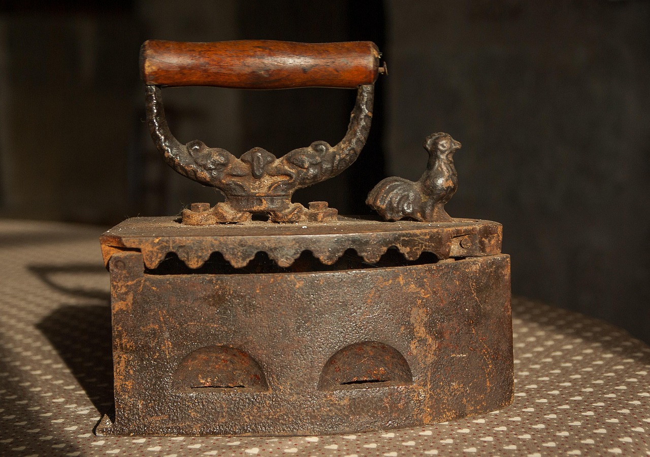 깔끔하게 다림질된 셔츠와 함께 놓인 현대적인 다리미 모습