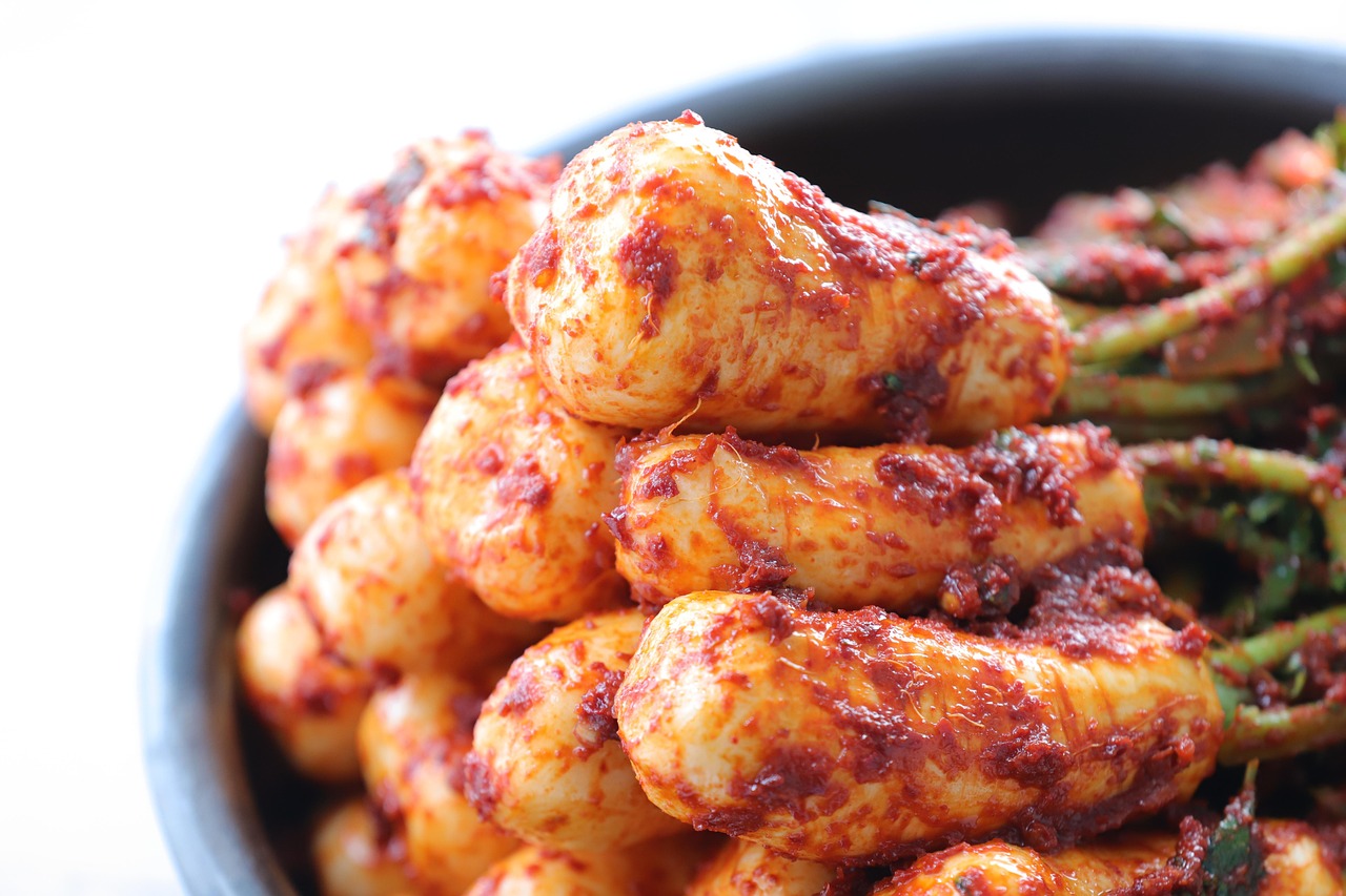 신선한 배추와 고춧가루로 만든 김치를 담그는 모습의 사진